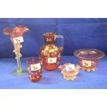 Five pieces of assorted cranberry glass to include vases, florally decorated jug,