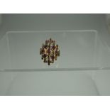 A 14ct GOLD AND RUBY CLUSTER RING.  The