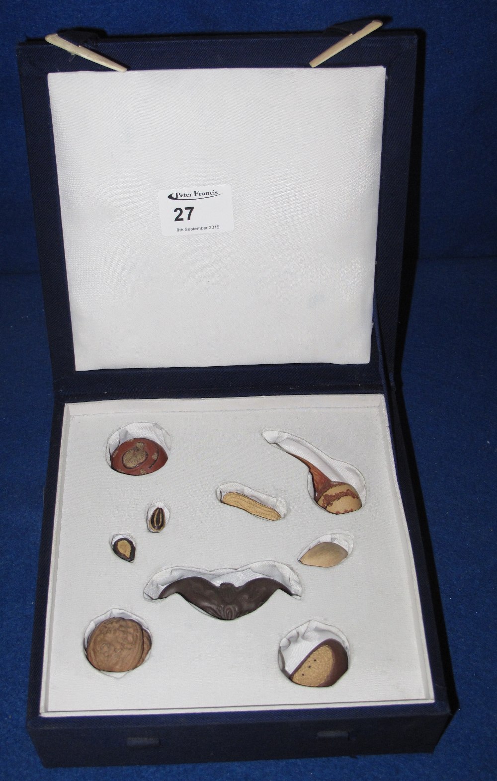 Fitted case containing a collection of Chinese ceramic models of nuts and seeds.