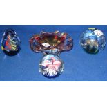 A glass dump type paperweight with bubble interior together with two other glass paperweights and a