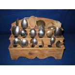 Traditional Welsh pine three stage spoon rack with an assortment of plated and wooded spoons.