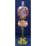 Early 20th century brass double burner oil lamp with painted glass reservoir on a brass base,