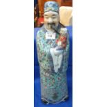 Large Chinese porcelain standing figure of an immortal holding a baby.  Square seal mark to base.