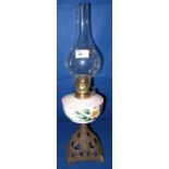 Early 20th century brass single burner oil lamp with ceramic floral painted reservoir on a pierced