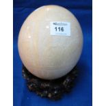 African or tribal carved ostrich egg with associate hardwood stand.
*** CONDITION REPORT: One