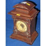 Small German architectural wooden mantle clock with back winding movement.