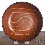 Pennsylvania slip decorated redware shallow bowl, 19th c., 8 1/2" dia. Two small flakes to rim.