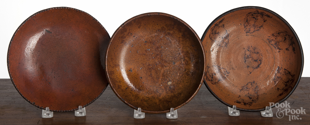 Three redware plates, 19th c., one with manganese splotching, 7 1/2" dia., 7" dia., and 7 1/2"