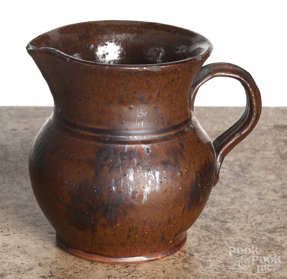 Pennsylvania redware cream pitcher, 19th c., with manganese splotching, 4 1/4" h. Small rim chips,