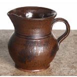 Pennsylvania redware cream pitcher, 19th c., with manganese splotching, 4 1/4" h. Small rim chips,