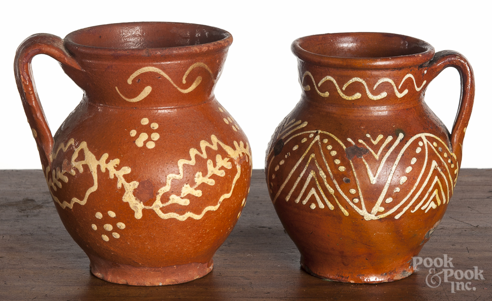 Two Mexican slip decorated redware pitchers, 19th c., 6 3/4" h. and 6 1/4" h. Tallest - glaze