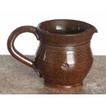 R. R. Stahl redware cream pitcher, signed and dated 1953, with a floral stamp around the waist, 3