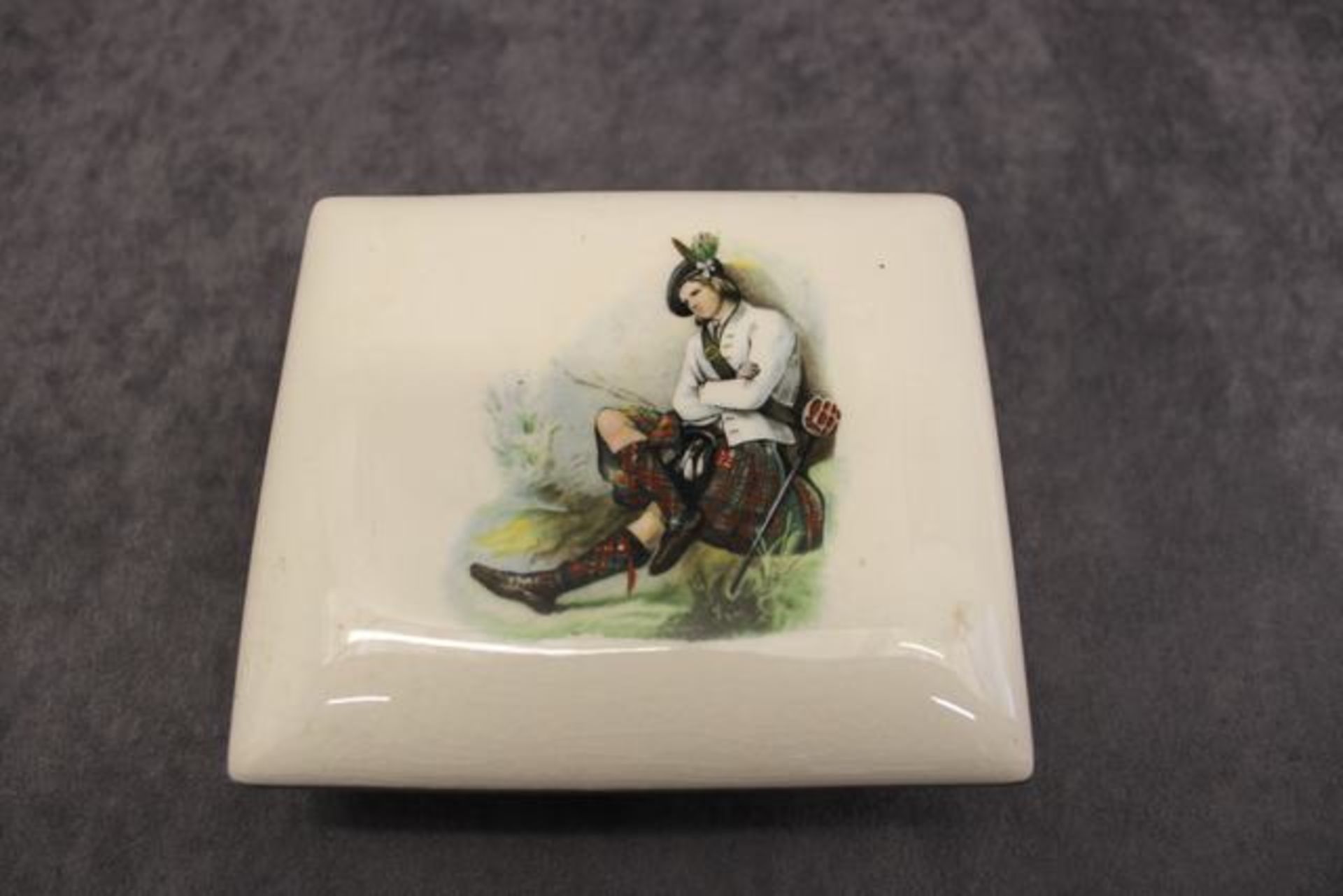 A porcelain trinket box and cover , early 20th Century,  decorated with a Scottish man resting,  a - Image 2 of 2