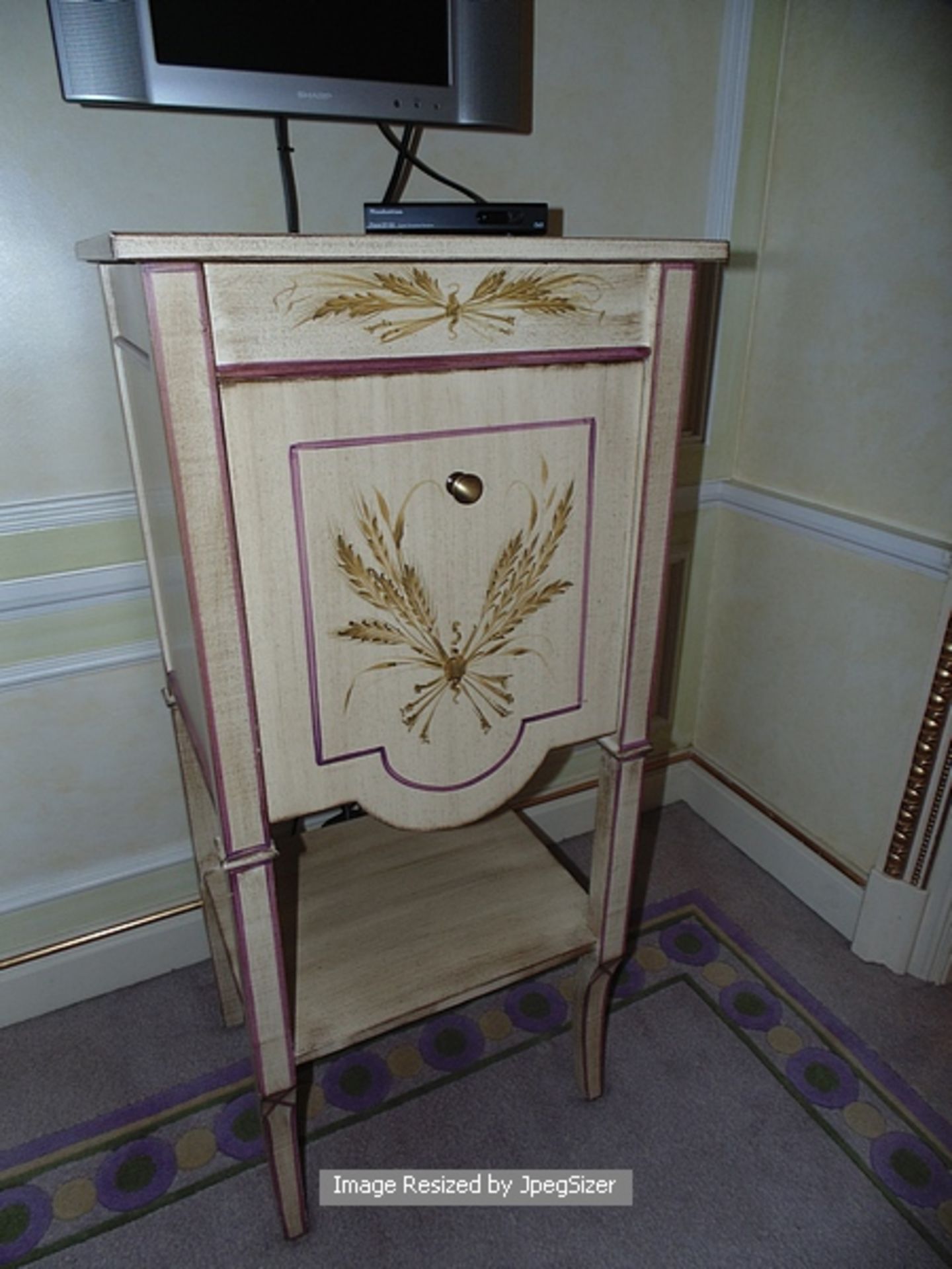 Painted and parcel gilt Louis XVI style commode , a single pull down cupboard above a single shelf