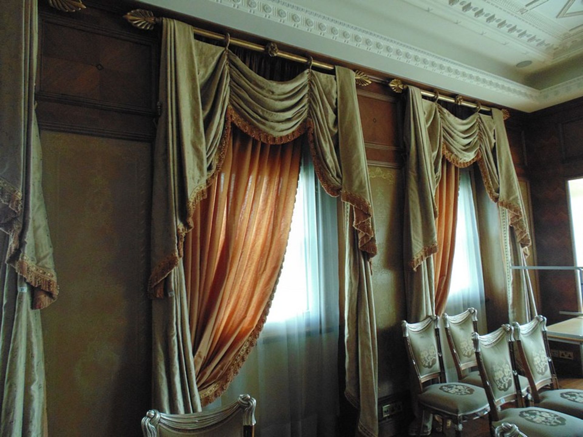 A pair of gold and burgundy curtains supplied by Jacquard from Rudolph Ackermann`s A series design