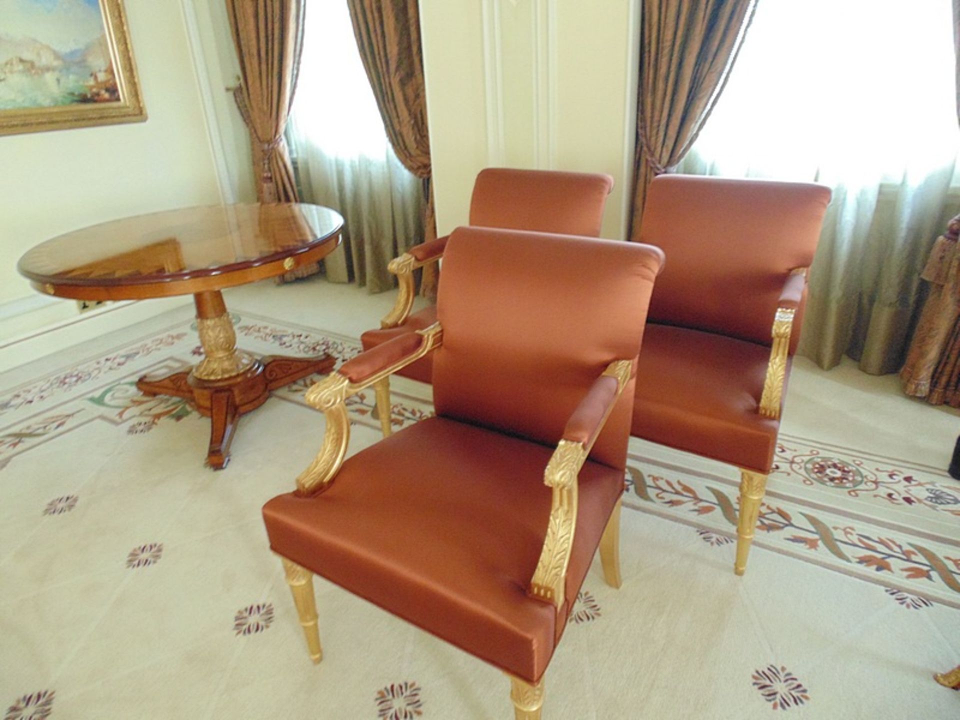 A set of three parcel gilt Neoclassical Fauteuils, with wide seats, fluted legs and padded