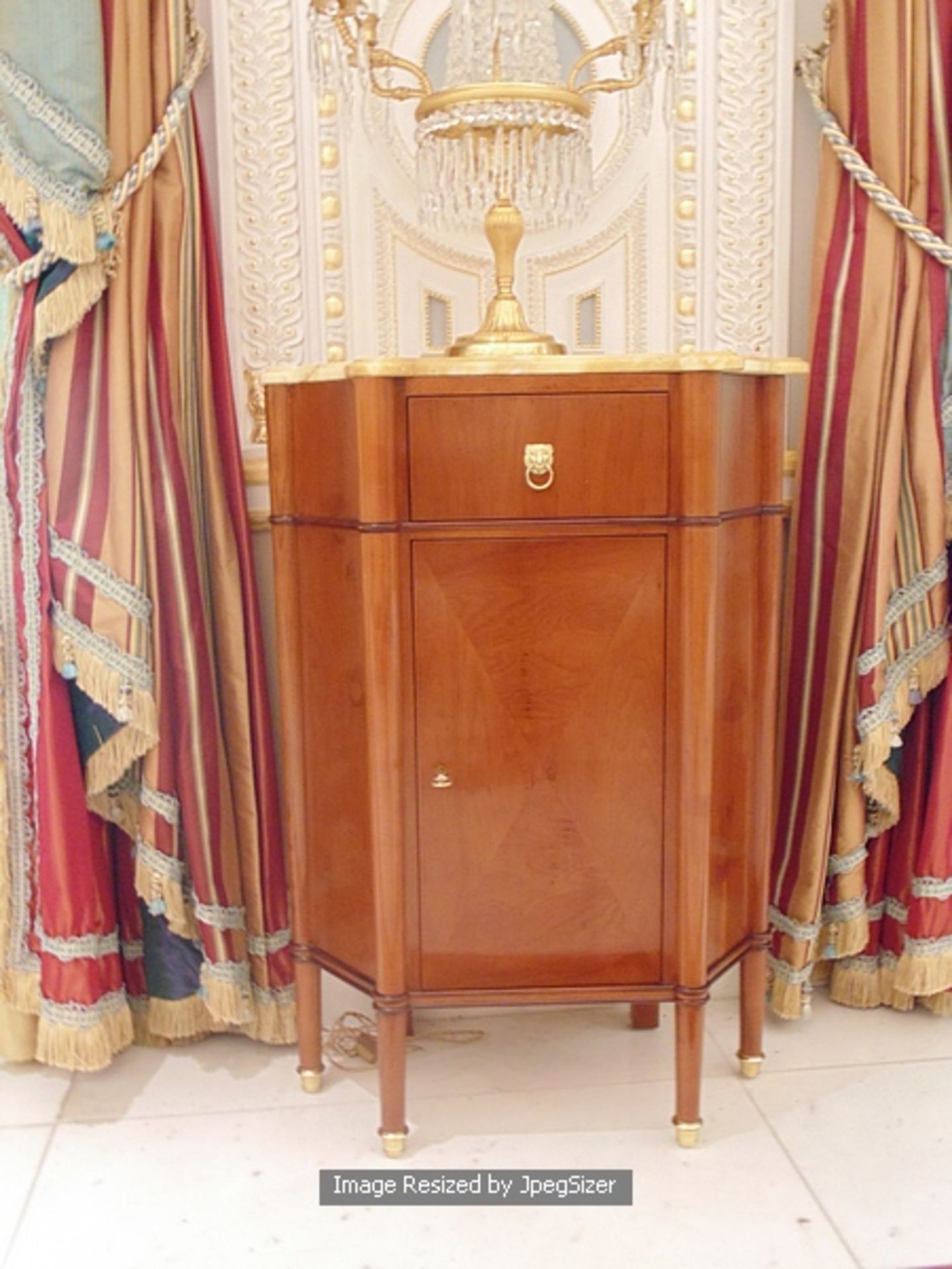 A pair of mahogany single drawer single cupboard marble top table, a shaped top mounted above a