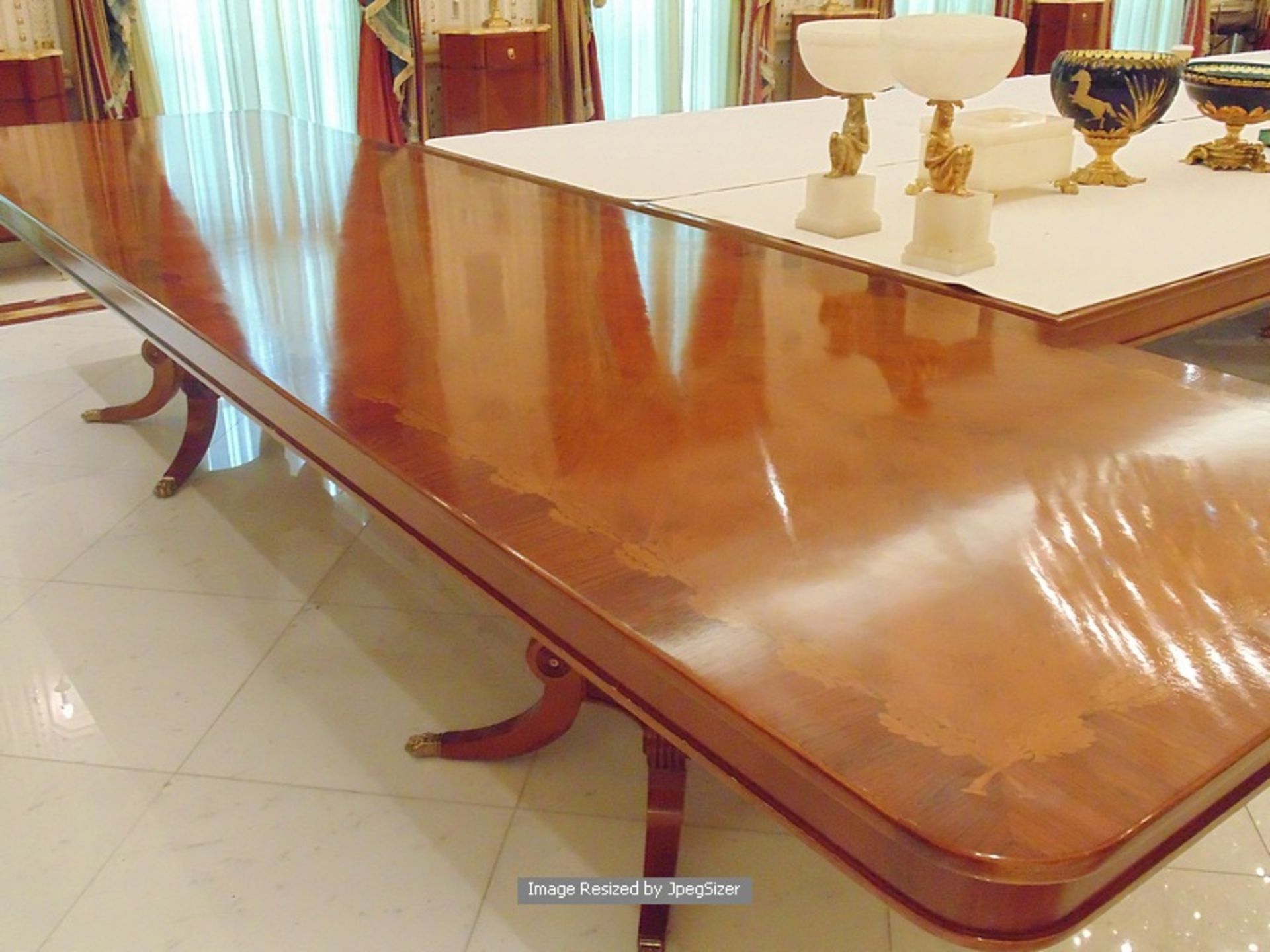 A Regency style mahogany and rosewood banded dining table, the mirror veneered top enclosed by - Image 7 of 8