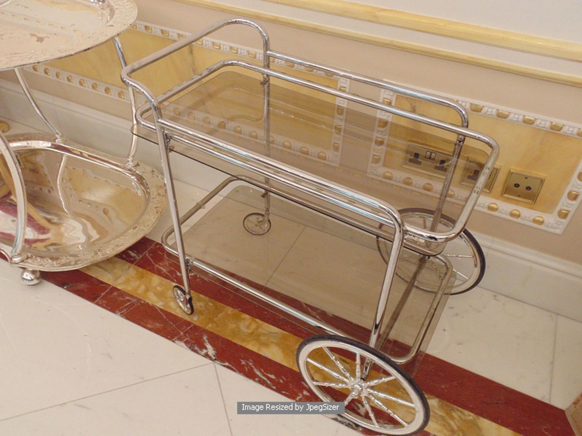 A two tier chrome and gilt service trolley 750mm x 430mm x 690mm