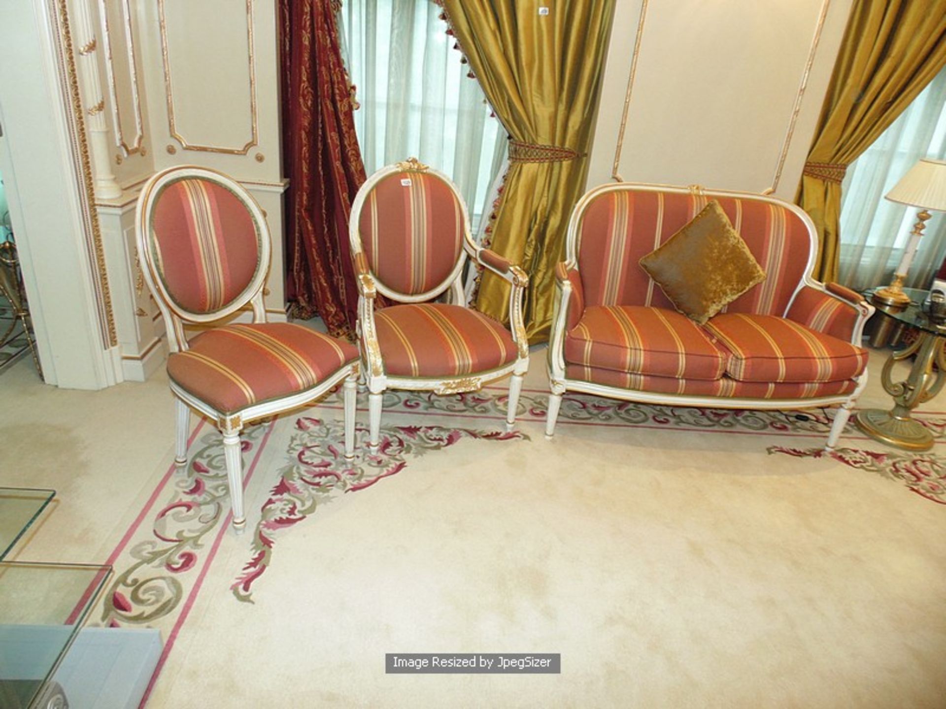 A Neoclassical salon painted and gilt suite comprising of a sofa, and a fauteuil arm chair and