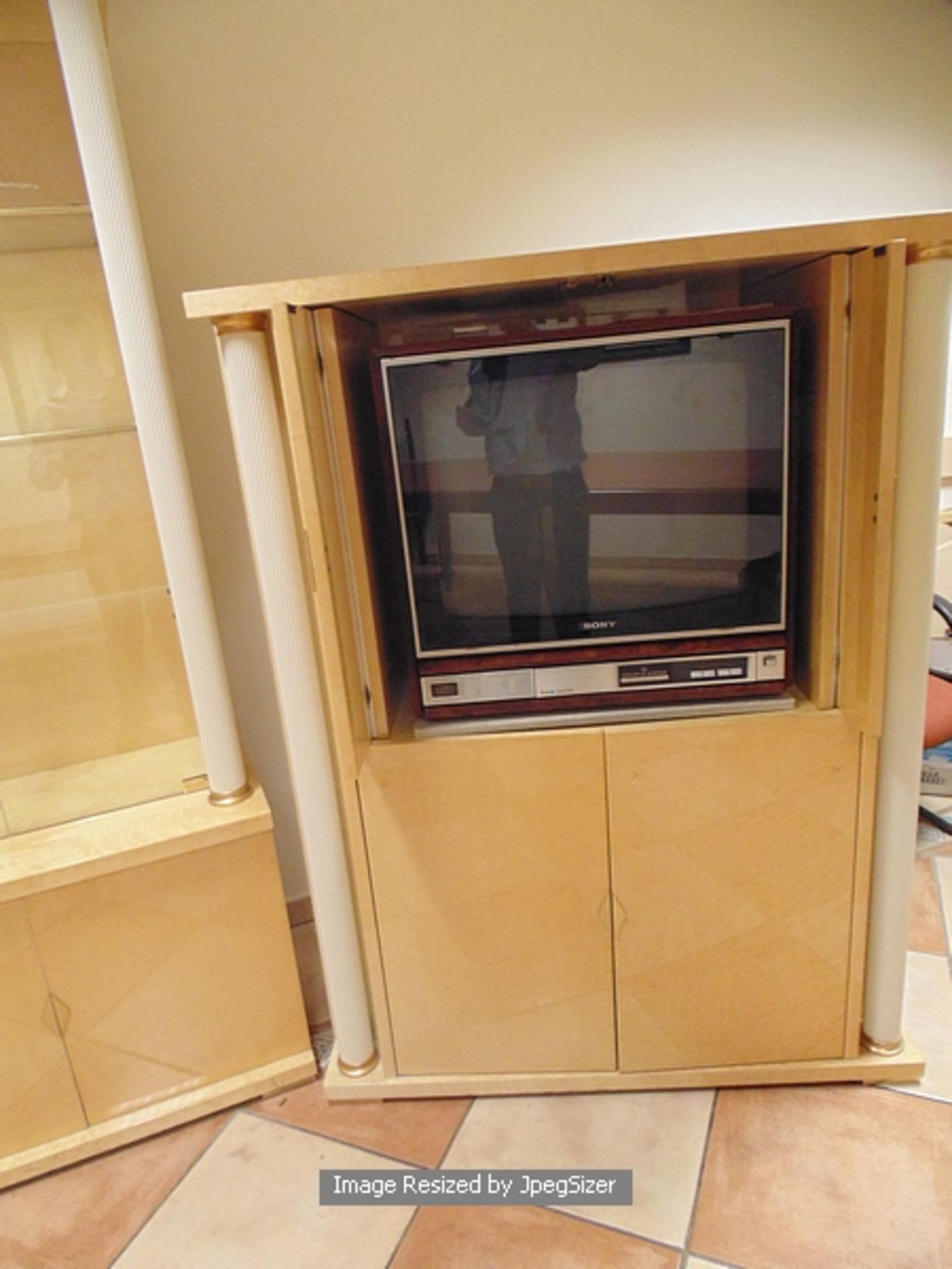 A birds eye maple TV audio cabinet with retractable top doors with reeded painted metal pillar