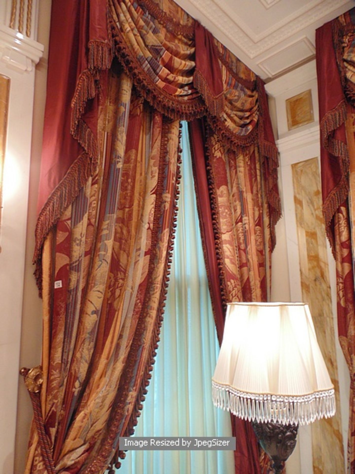 A pair of gold and burgundy curtains supplied by Jacquard from Rudolph Ackermann`s A series design