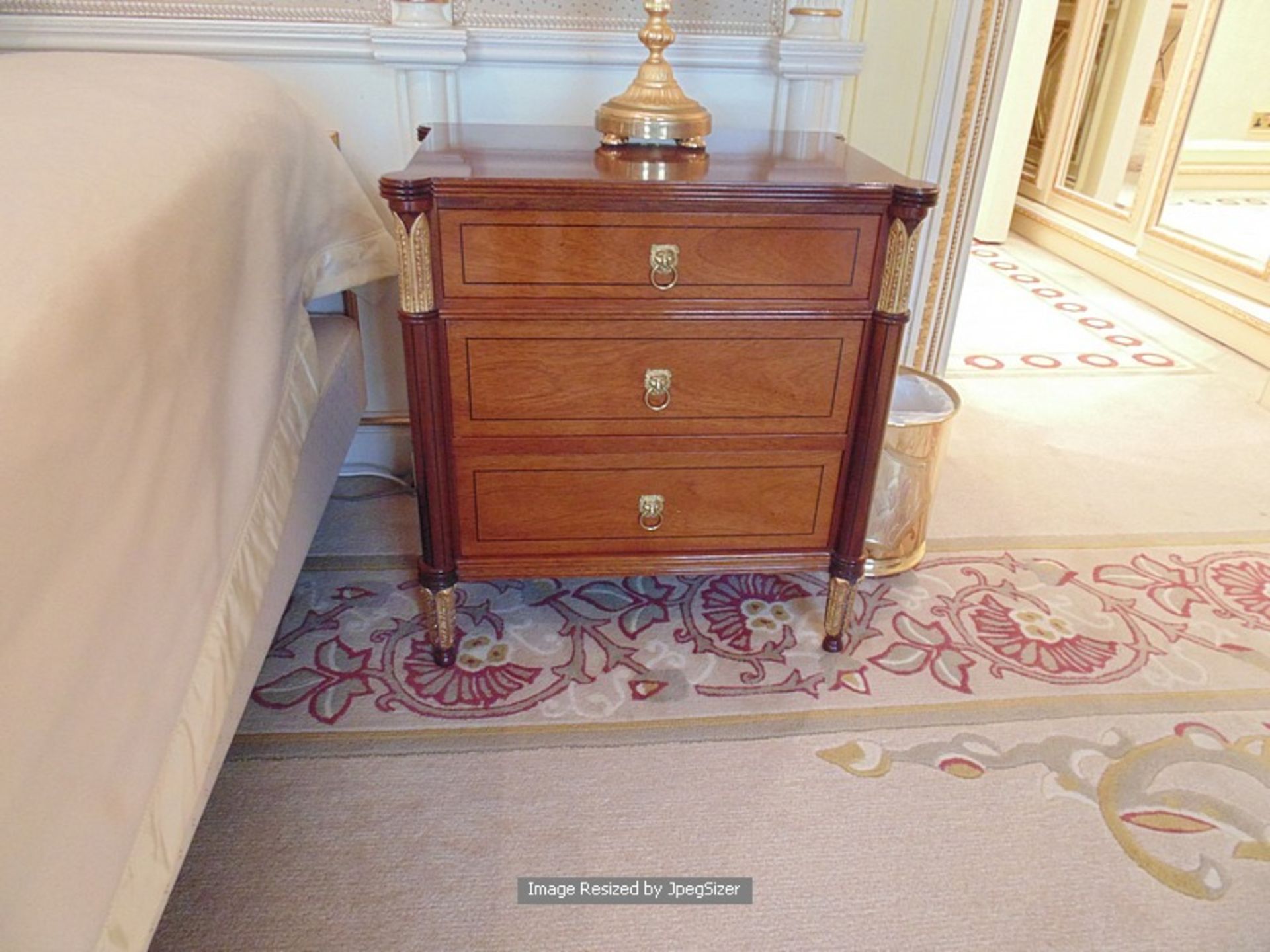 A pair of Empire style three drawer nightstand chests with veneer panelled downs and ormolu mounts