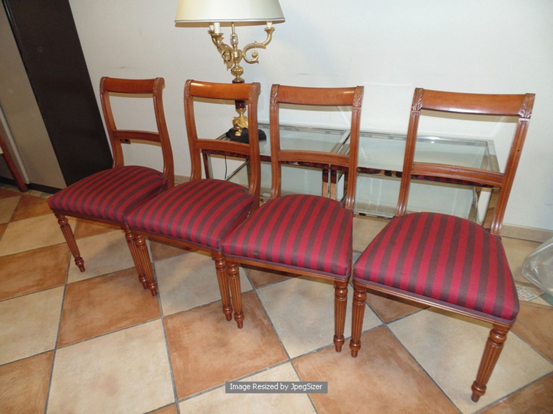 A set of four Regency style mahogany dining chairs, moulded top rails over a central carved splat