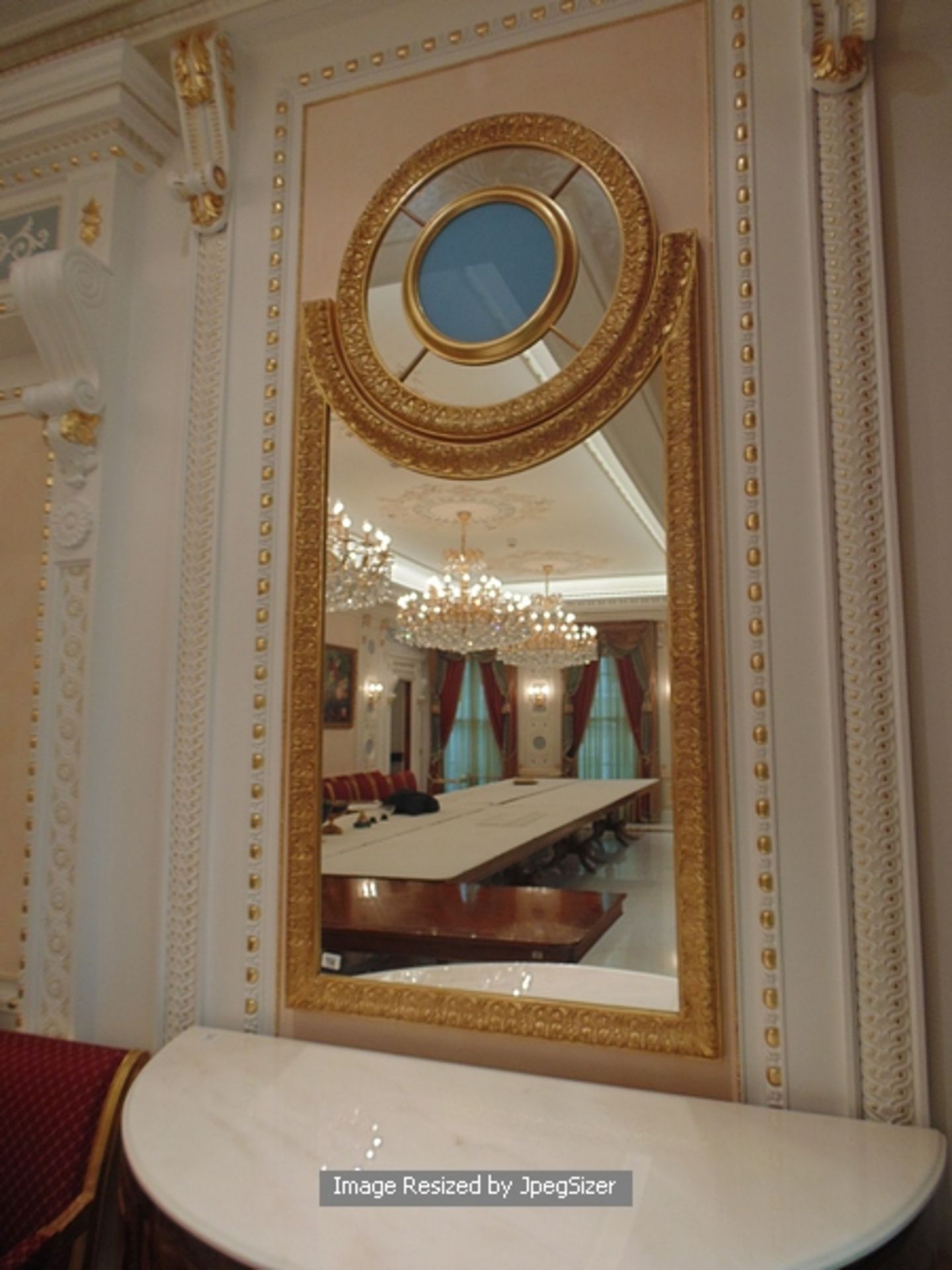 A neoclassical style carved and gilded mirror, a two part mirror with the main frame of the mirror