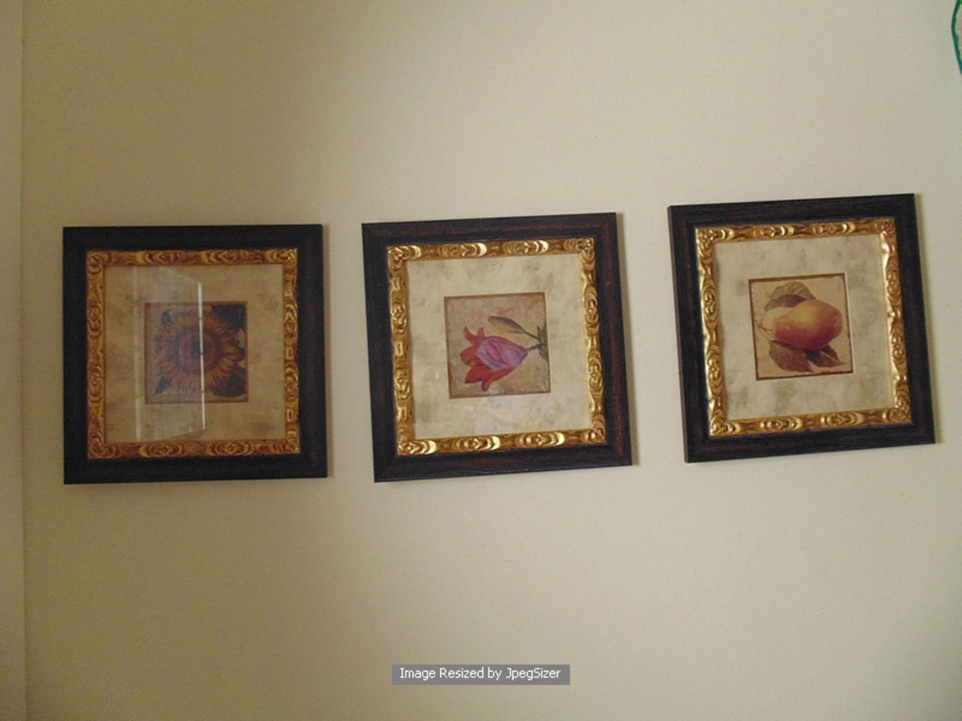 A set of three still life floral paintings on board mounted in a wood and gilt painted frame