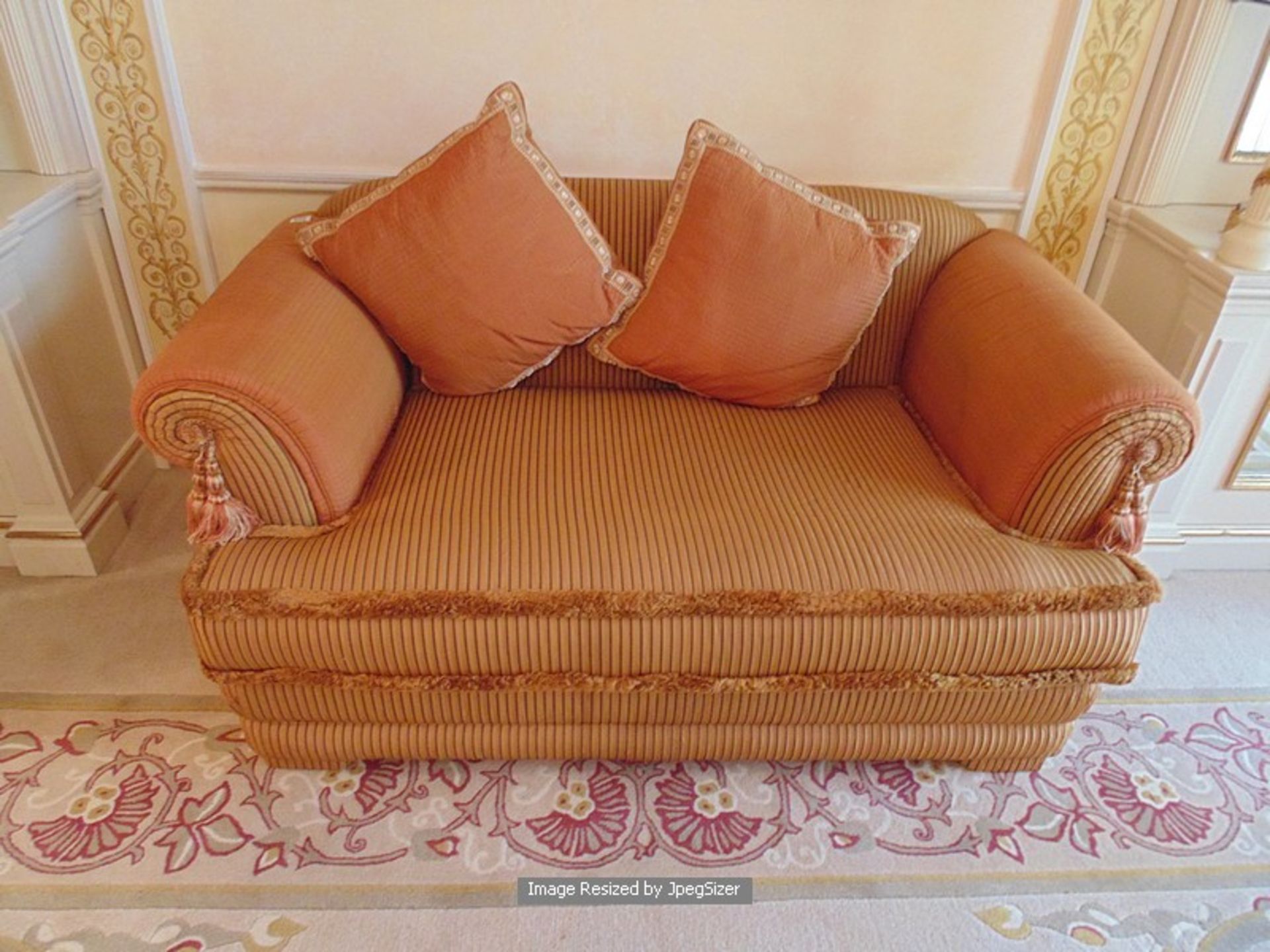 A two seater heavy padded upholstered sofa low back scroll arms in gold draylon type fabric 700mm