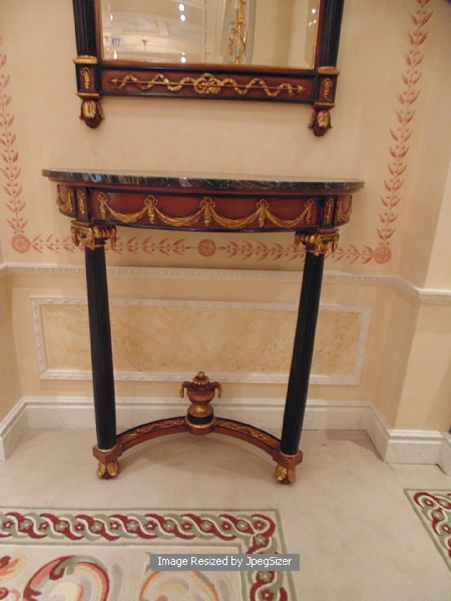 Empire style giltwood and mahogany demi line table with marble top mounted on a concave stretcher