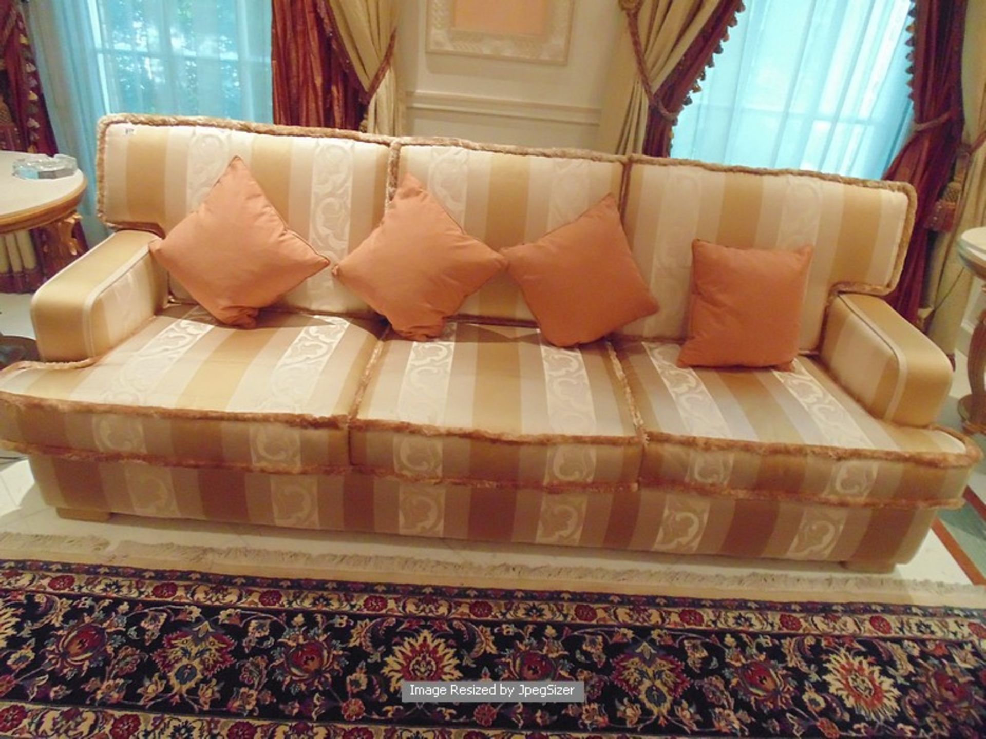 An upholstered heavily padded three piece suite comprising of three seater sofa upholstered in cream