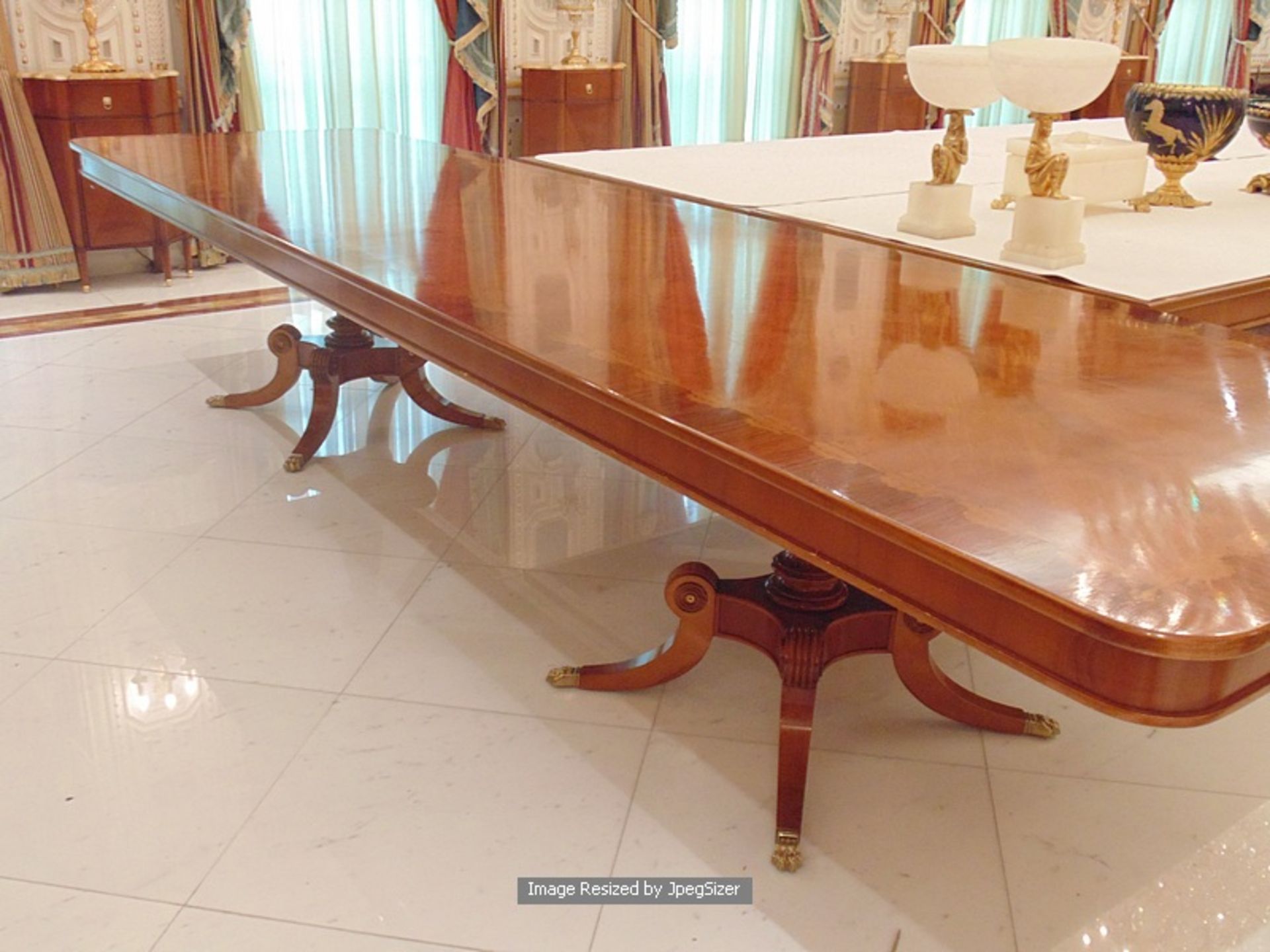 A Regency style mahogany and rosewood banded dining table, the mirror veneered top enclosed by - Image 3 of 8