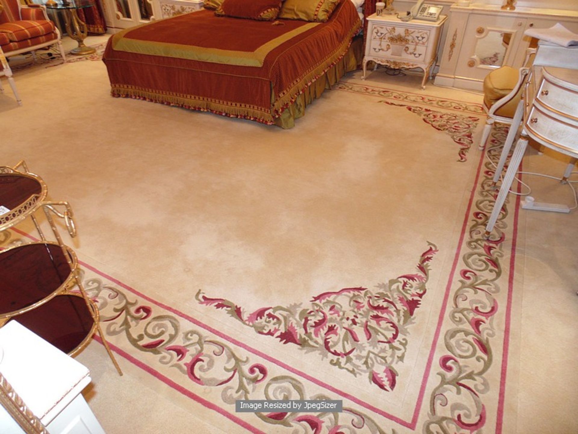 A sumptuous 100% pure new wool carpet 6m x 4.5m cream field with a classic swirl pattern border