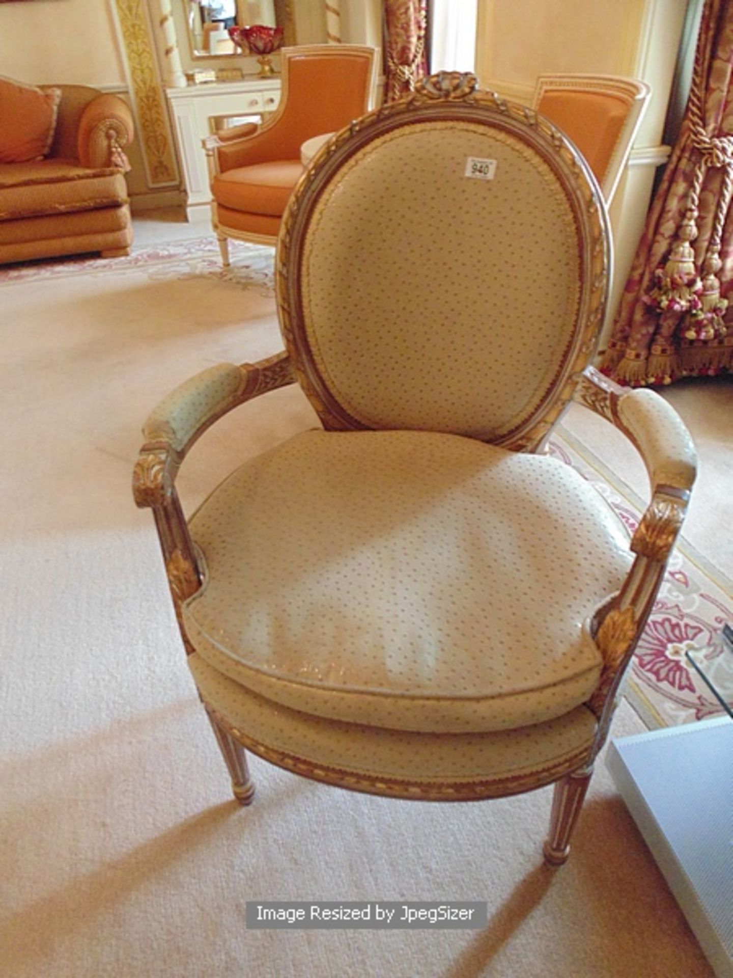 Neoclassical style arm chair with an oval padded back within a carved and moulded frame headed the