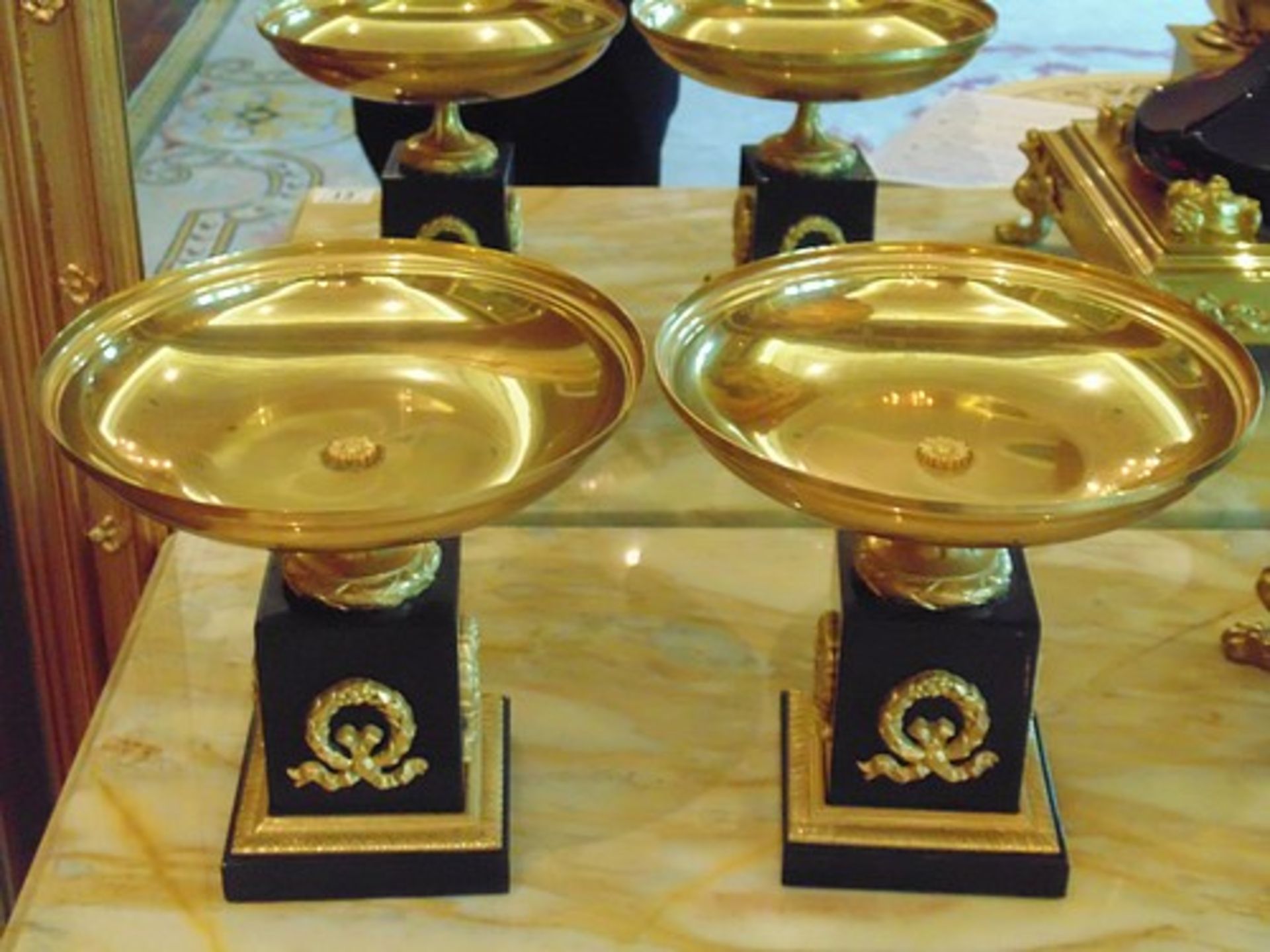 A pair of French Empire style Tazza on marble base, a single gilded bronze mounted on a square