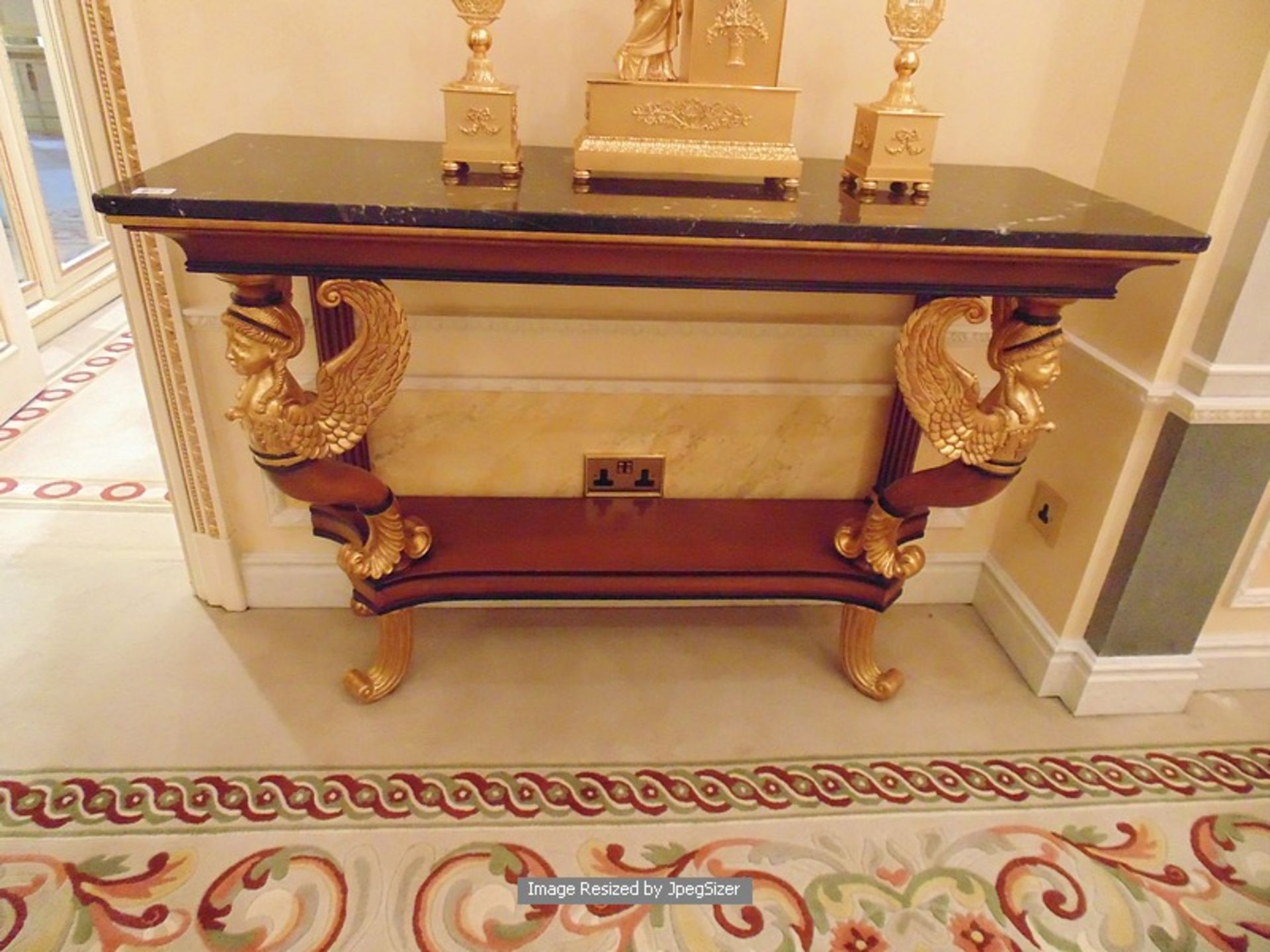 A mahogany and parcel-gilt console table in early 19th century Empire style, the mottled black