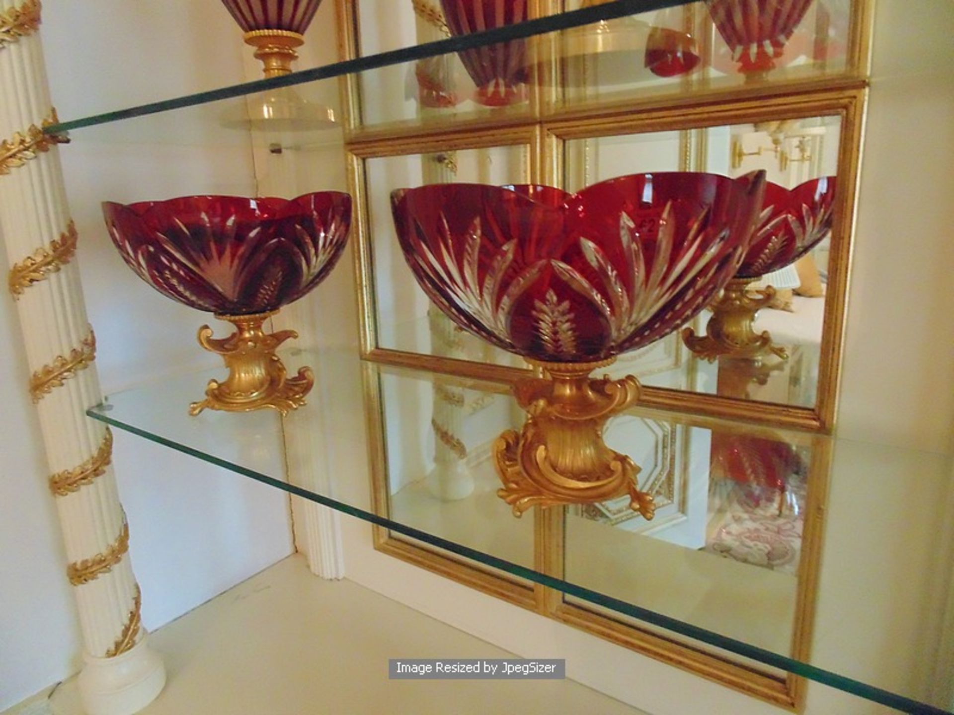 A pair of Baldi Home Jewels stunning ruby red and clear crystal cup bowls mounted on bronze plinth