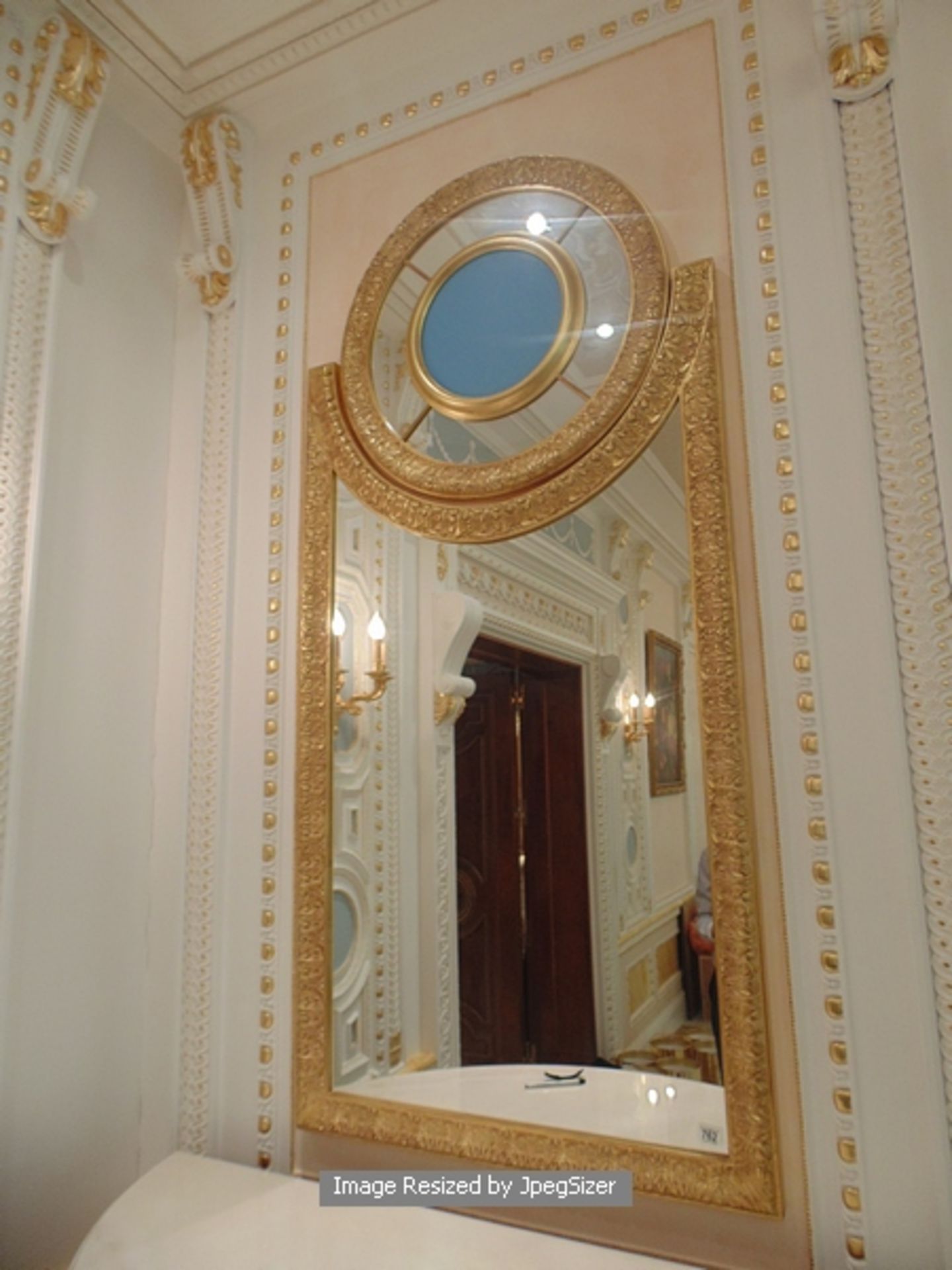 A neoclassical style carved and gilded mirror, a two part mirror with the main frame of the mirror