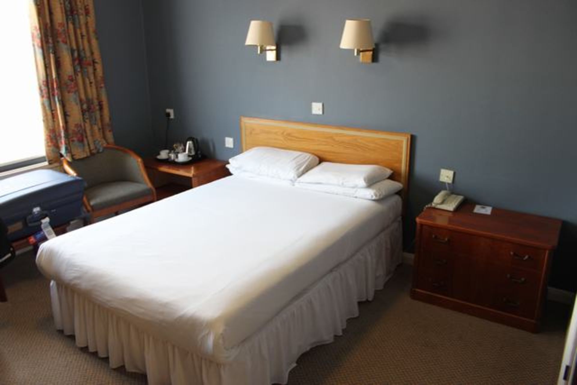 Room 103 comprising double bed, three drawer nightstand chest, audio cabinet, tub chair, coffee