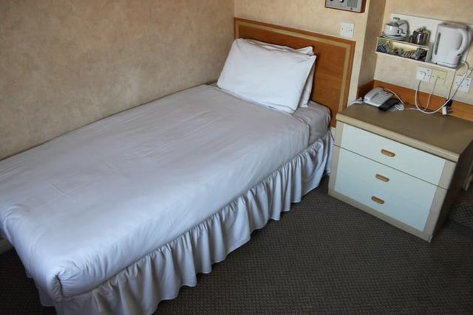 Room 101 comprising single bed, three drawer chest, circular occasional table, tub chair, desk,