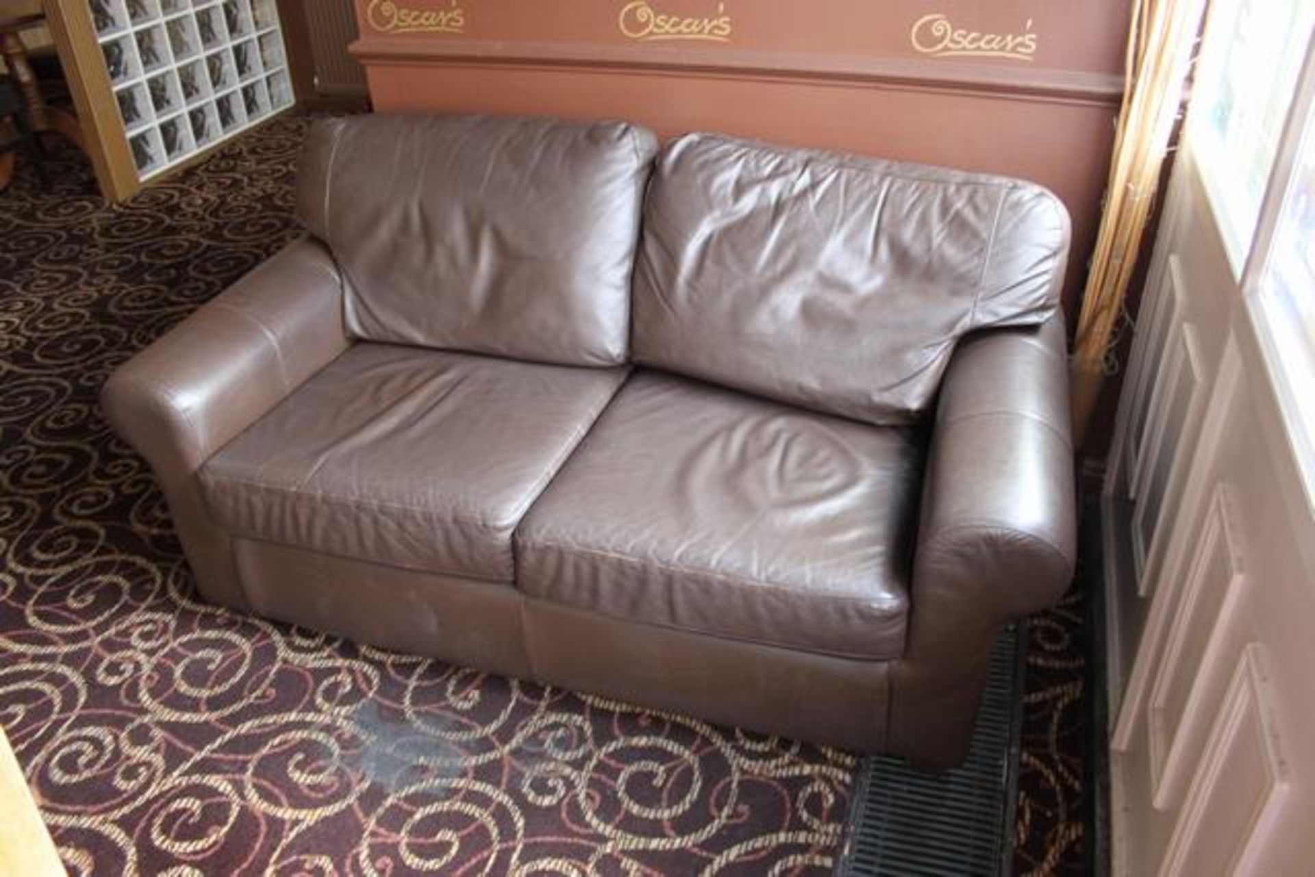 A two seater faux leather caramel brown sofa loose cushions on a solid wood frame the curved arms