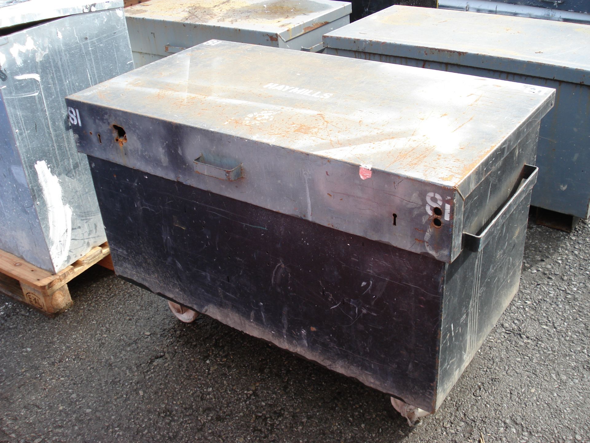 BLACK METAL STORAGE BOX ON WHEELS CONTAINING YELLOW WEIGHTS