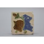 A Spanish olambrilla tile, Seville, first half 16th C. Decorated in relief with a beast and a flower