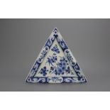 An unusual triangular blue and white Dutch Delft plate, late 17th C. Decorated with a bird in