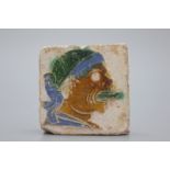 A Spanish olambrilla tile, Seville, first half 16th C. Decorated in relief with a man sticking out