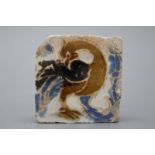 A Spanish olambrilla tile, Seville, first half 16th C. Decorated in relief with a phoenix in blue,