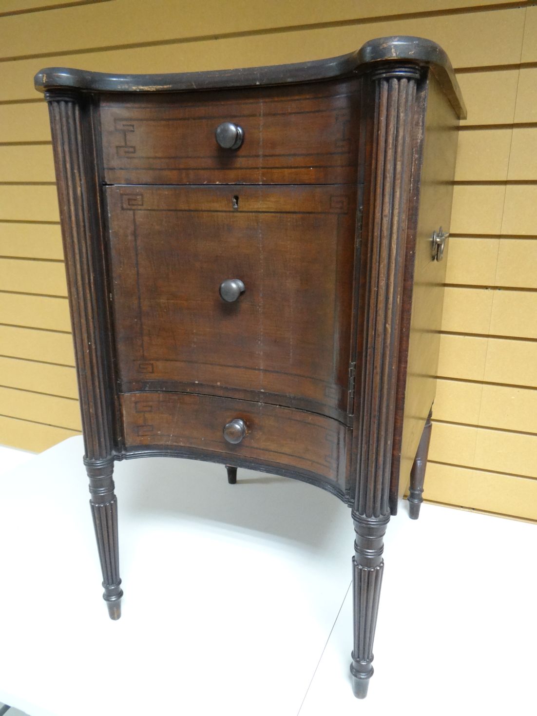 An early-twentieth century stained night-cabinet of concave-form, with reeded full column supports