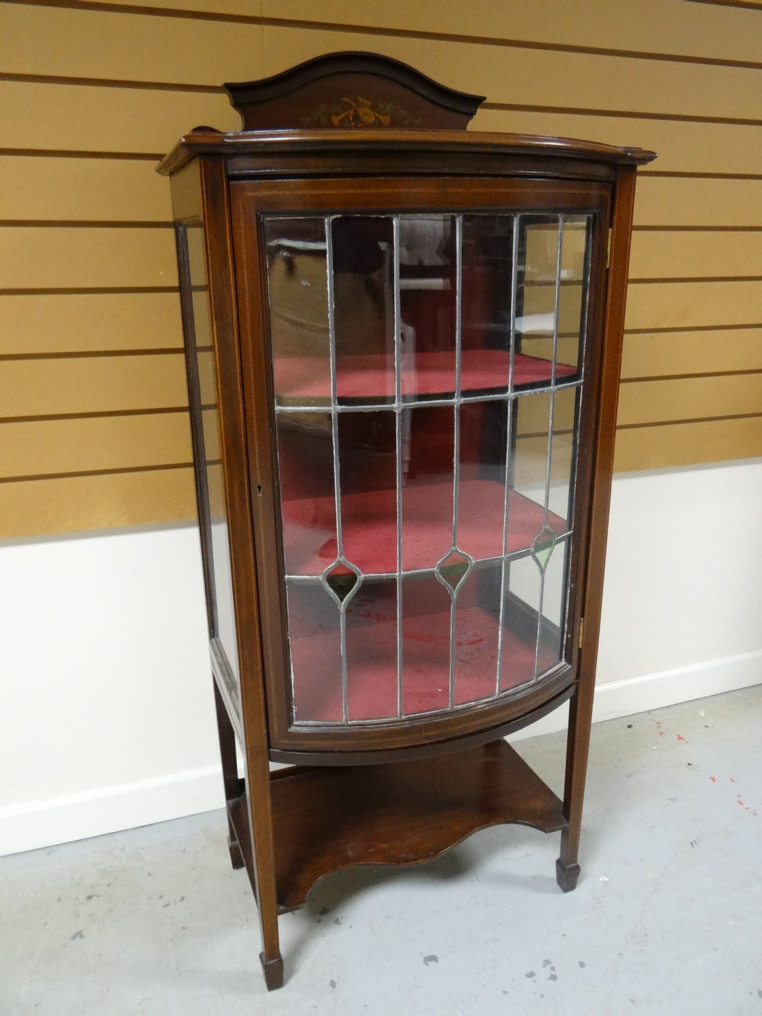 An inlaid mahogany single door china cabinet with shaped lower tier and leaded glass, 54 ins high (